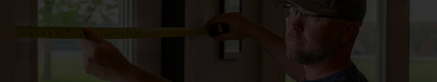 Maintenance worker of WPM measuring a wall with a tape measure