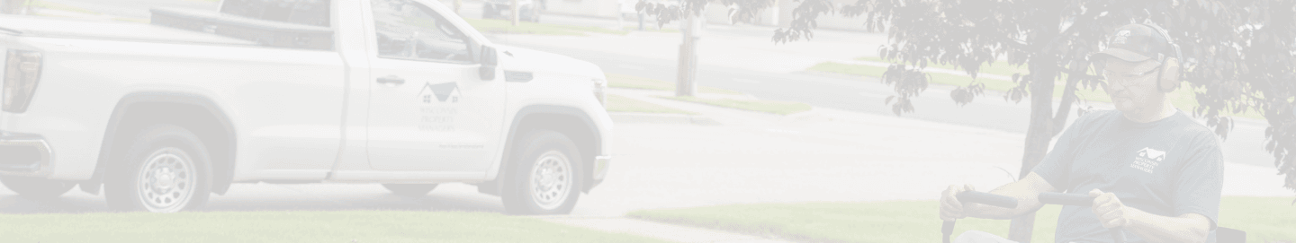 Maintenance worker of WPM riding a lawn mower, cutting the grass of a property